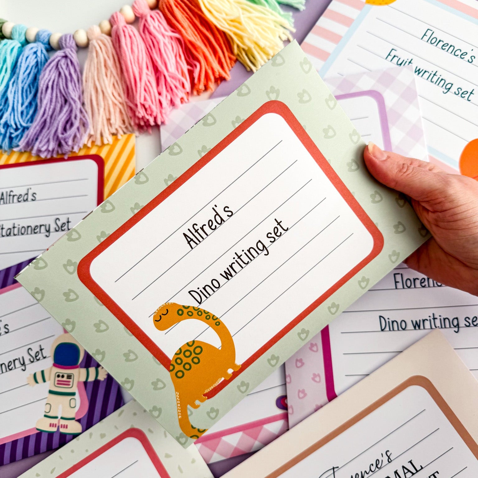 Personalised green dinosaur writing set for kids featuring letter paper, postcards, envelopes, and stickers, perfect for encouraging creativity and letter writing.