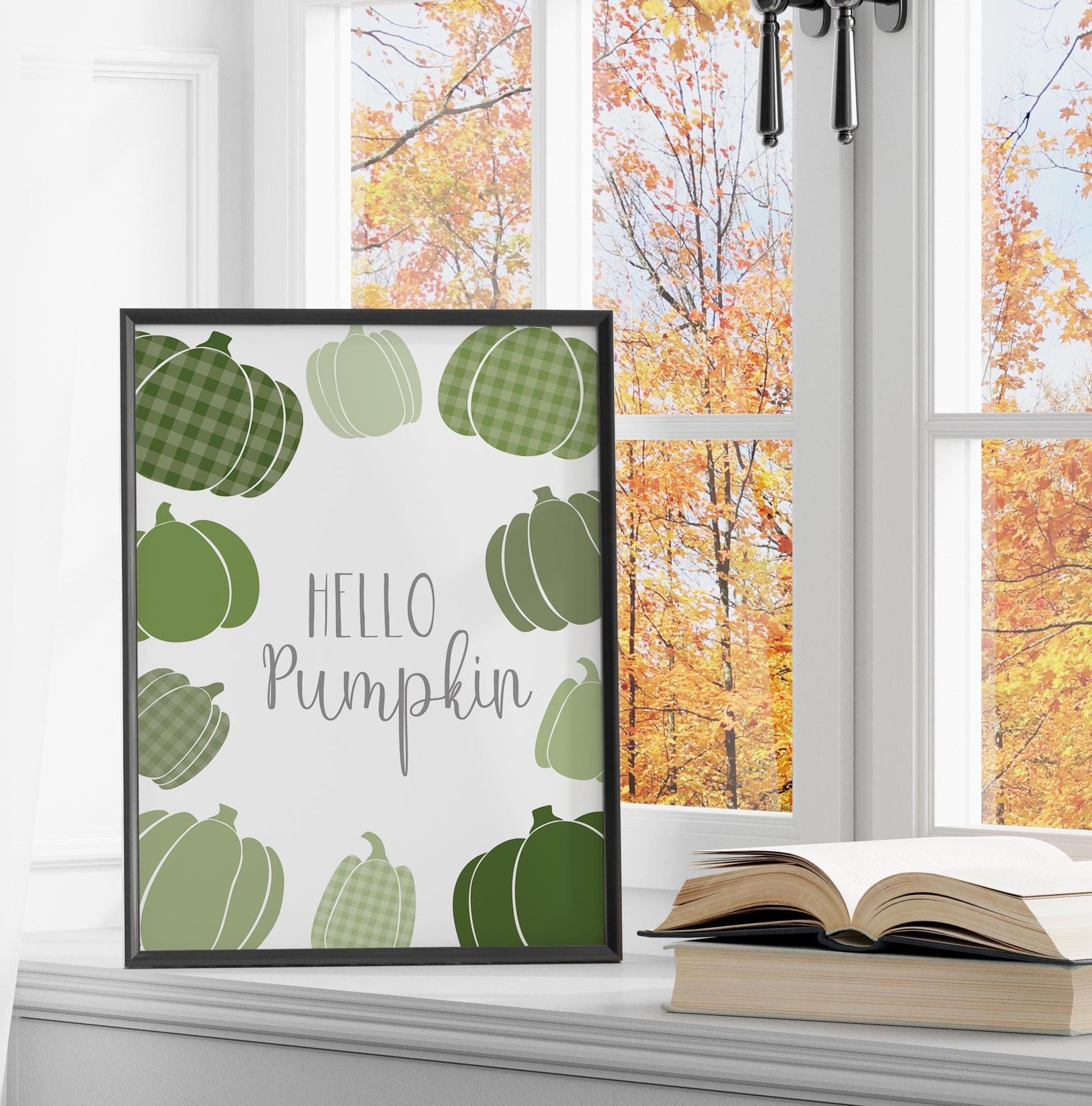 &quot;Hello Pumpkin&quot; art print with a mix of scattered pumpkins in different sizes and shades of green, styled in an autumn themed window.