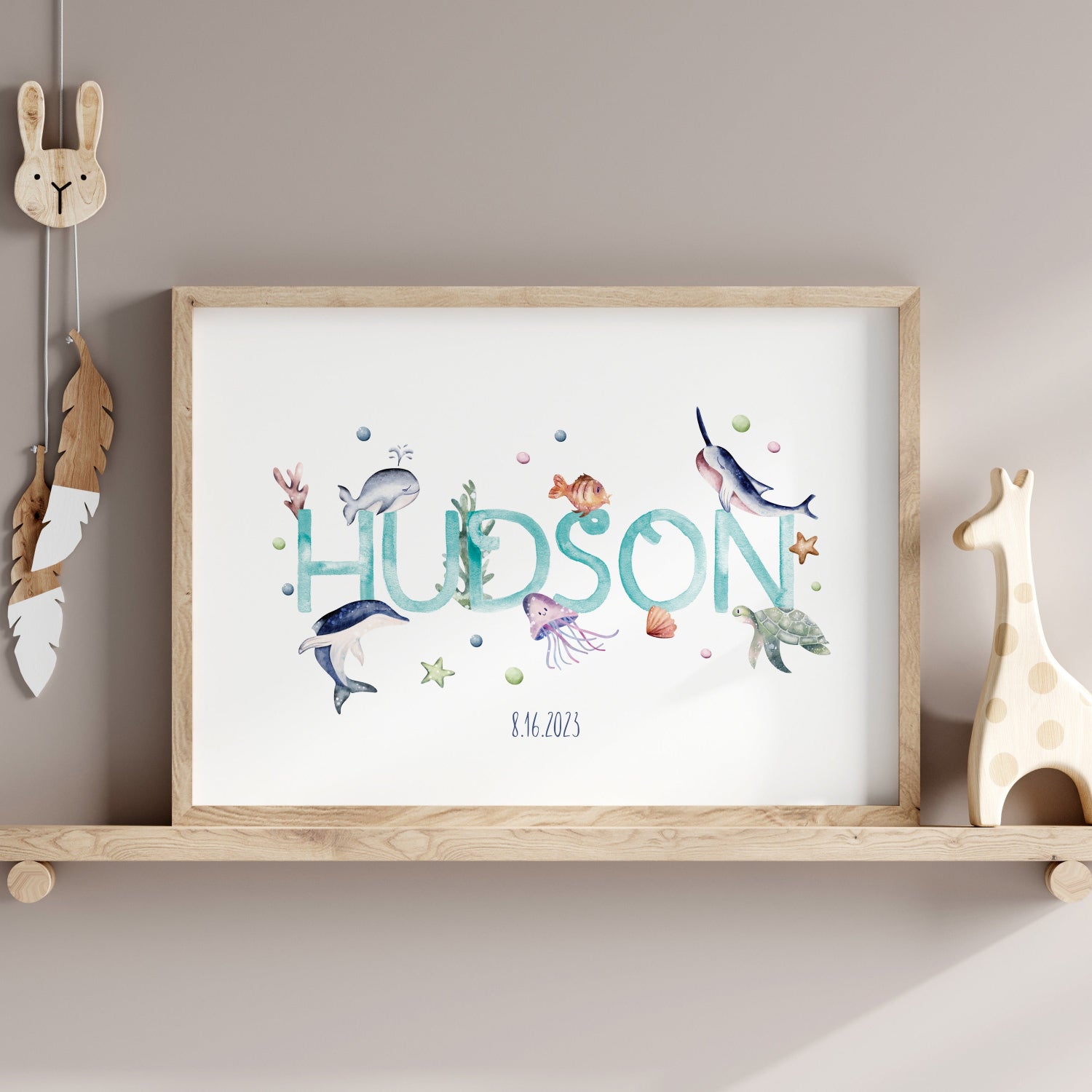 Watercolour ocean nursery print framed in a natural wood frame, complementing the nursery decor.