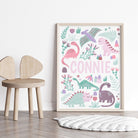 Close-up of a personalised pink dinosaur print featuring a child’s name for nursery decor.