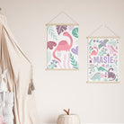 Pink dinosaur wall art prints displayed as part of kids' room decor with playful accessories.