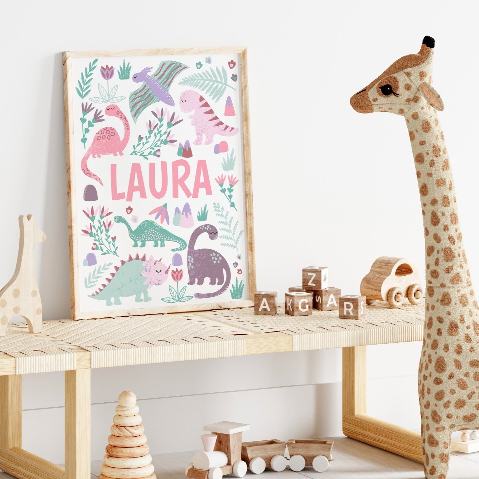 Close-up of a pink dinosaur wall art print with a personalised name option for kids' rooms.